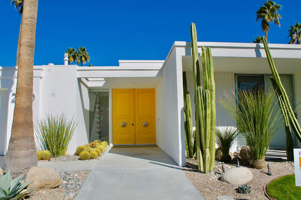 Sunlit modern home entry with spotless windows and bright yellow front doors