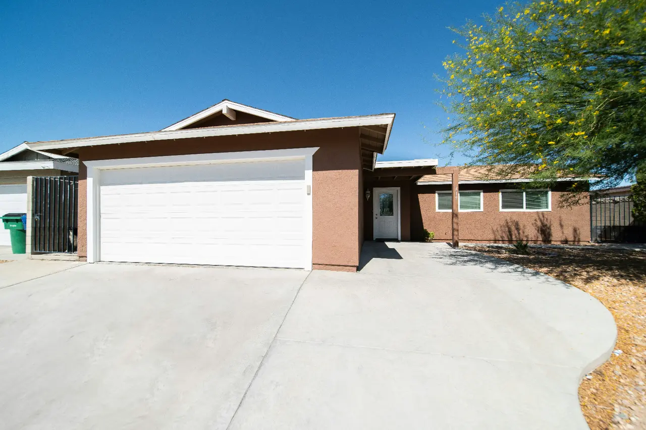 Freshly pressure-washed concrete driveway leading to a two-car garage
